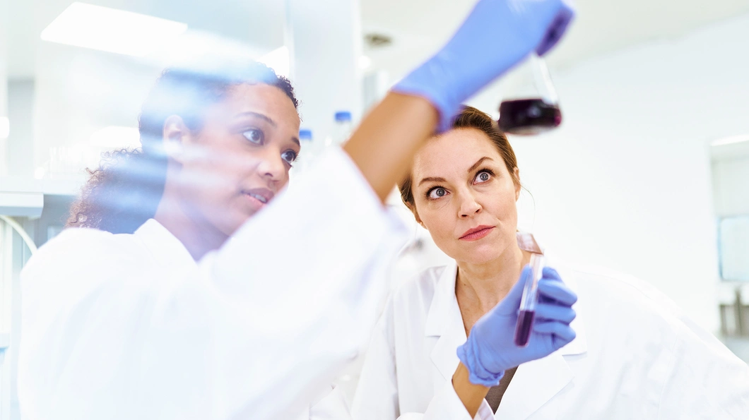 Close-up of researchers in a lab, looking at findings